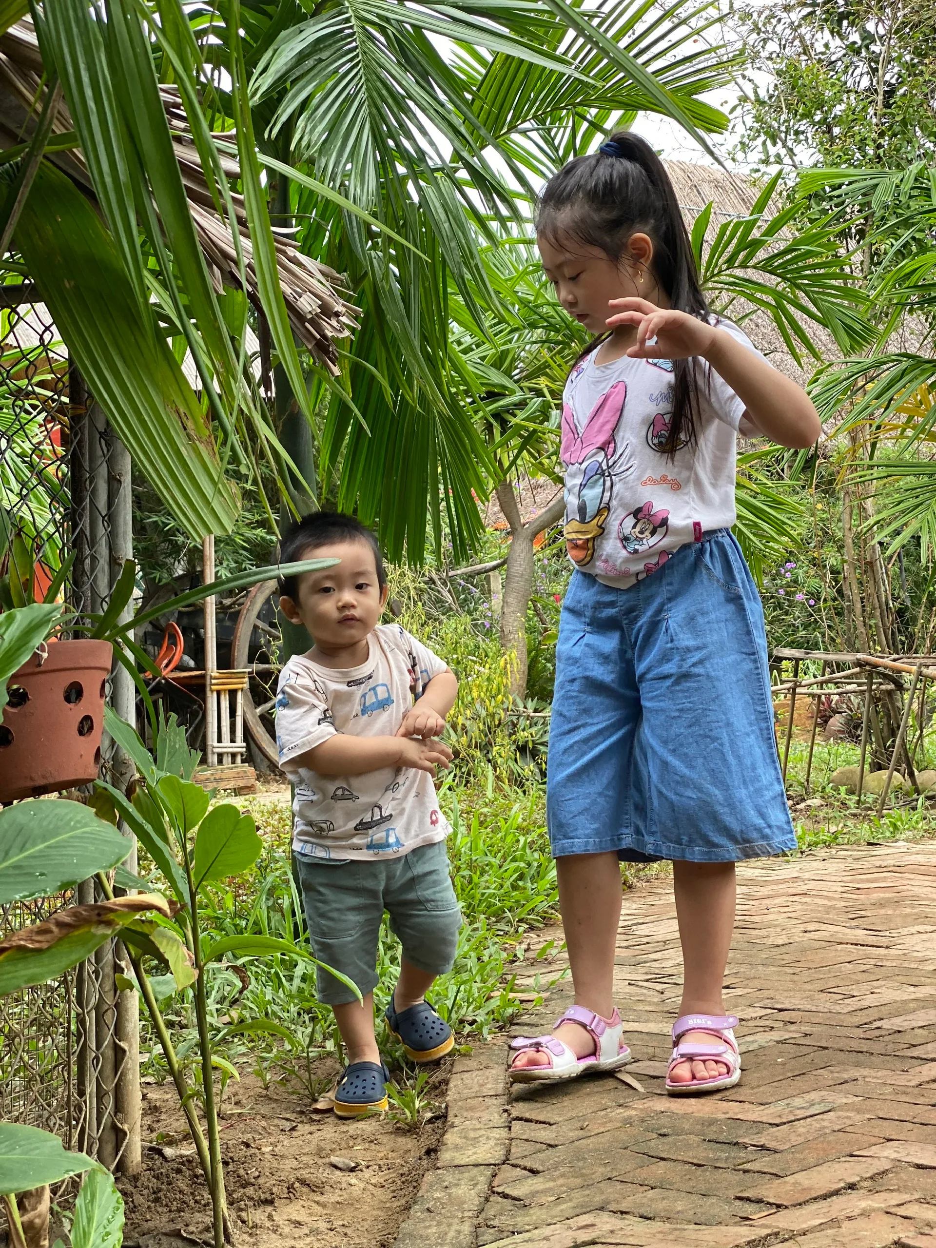 English-speaking babysitter playing with two kids in a Da Nang hotel room during daily care