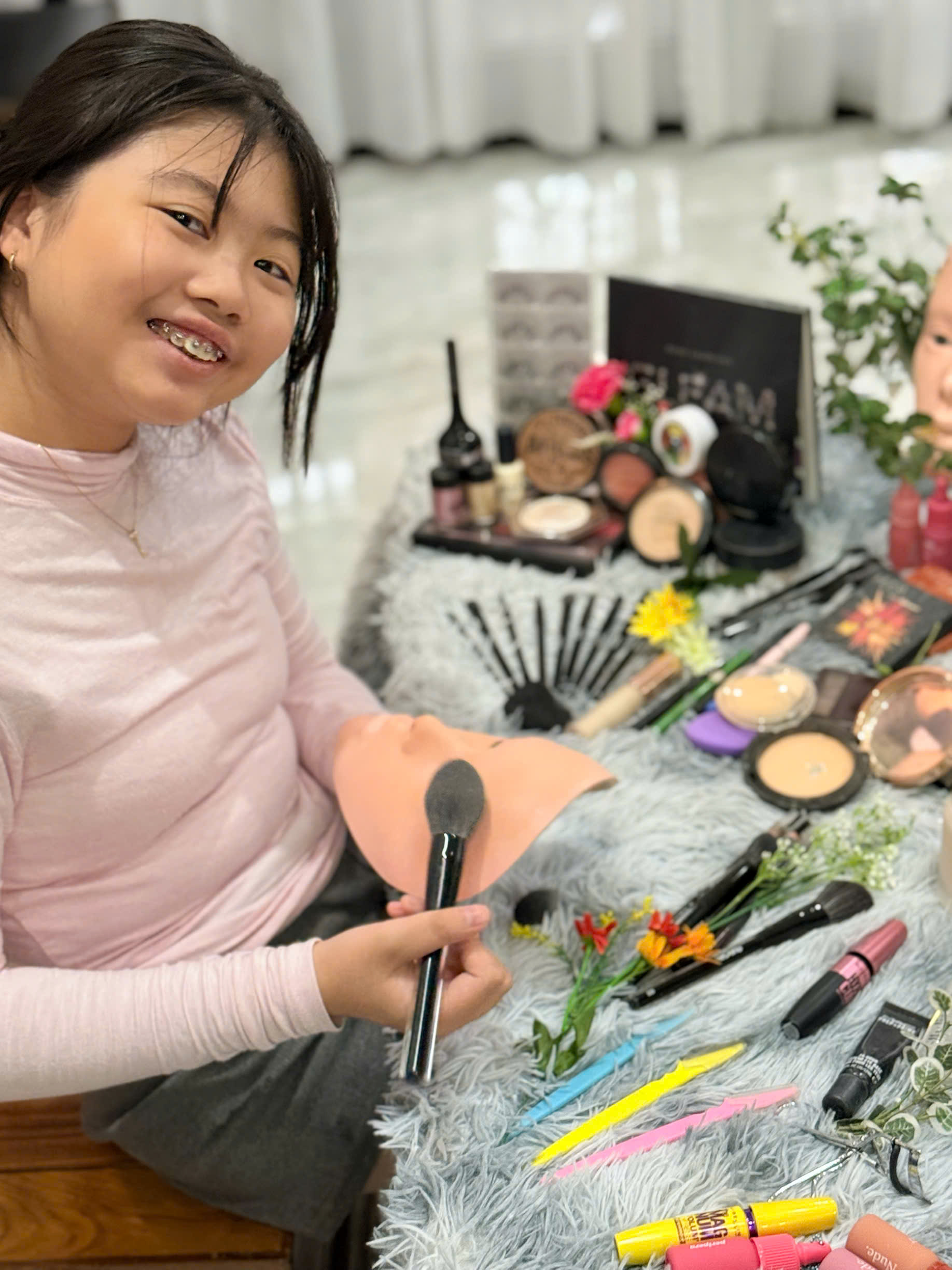 Babysitter guiding a child to do kid-safe mini makeup on a mask during daily babysitting