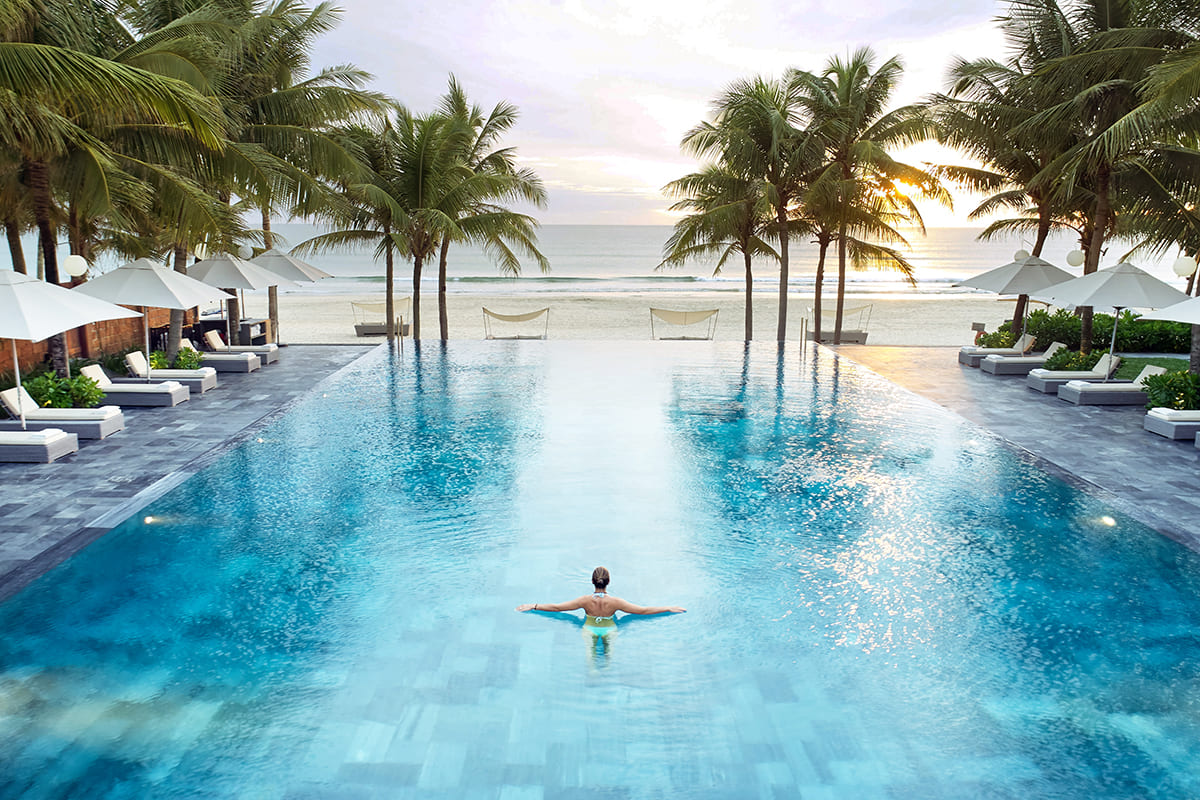 Happy child enjoying time with babysitter at TIA Wellness Resort while parents relax nearby